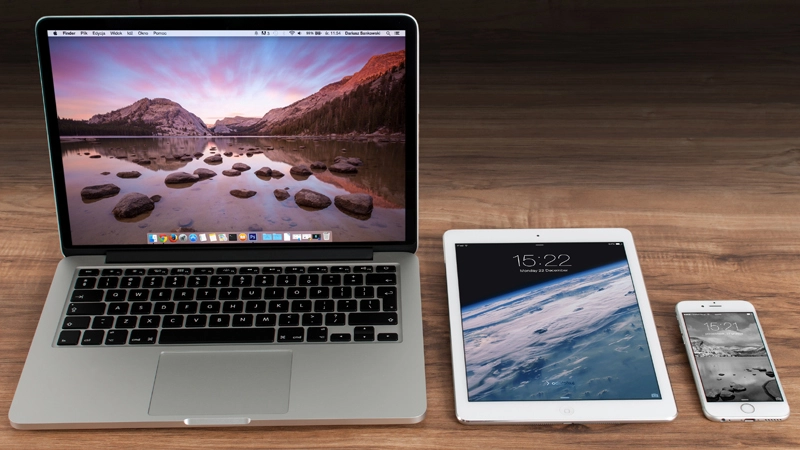 The platform choice impacts the cost of MVP development Laptop, tablet, and smartphone placed on a wooden desk
